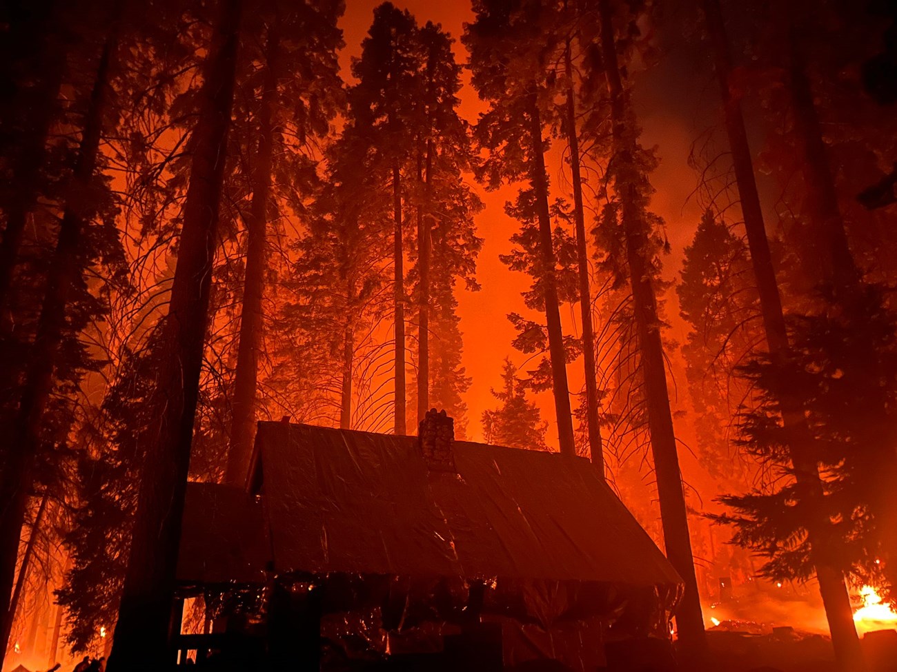 A structure has protective wrap around in while flames surround it.