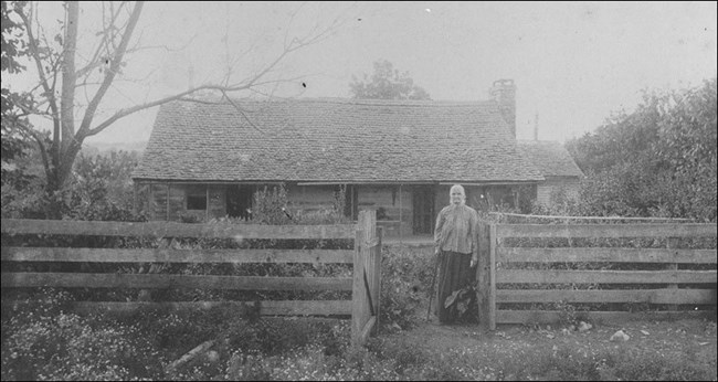 A woman standing in front of a house