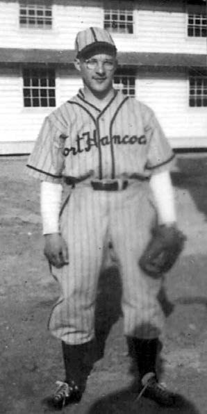 a young man in a baseball uniform reading Fort Hancock