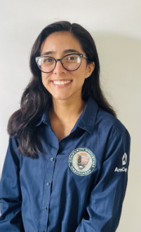 Natalie wearing a navy long sleeve collared shirt. The logo on the right breast has the official logo of the Community Volunteer Ambassador program.