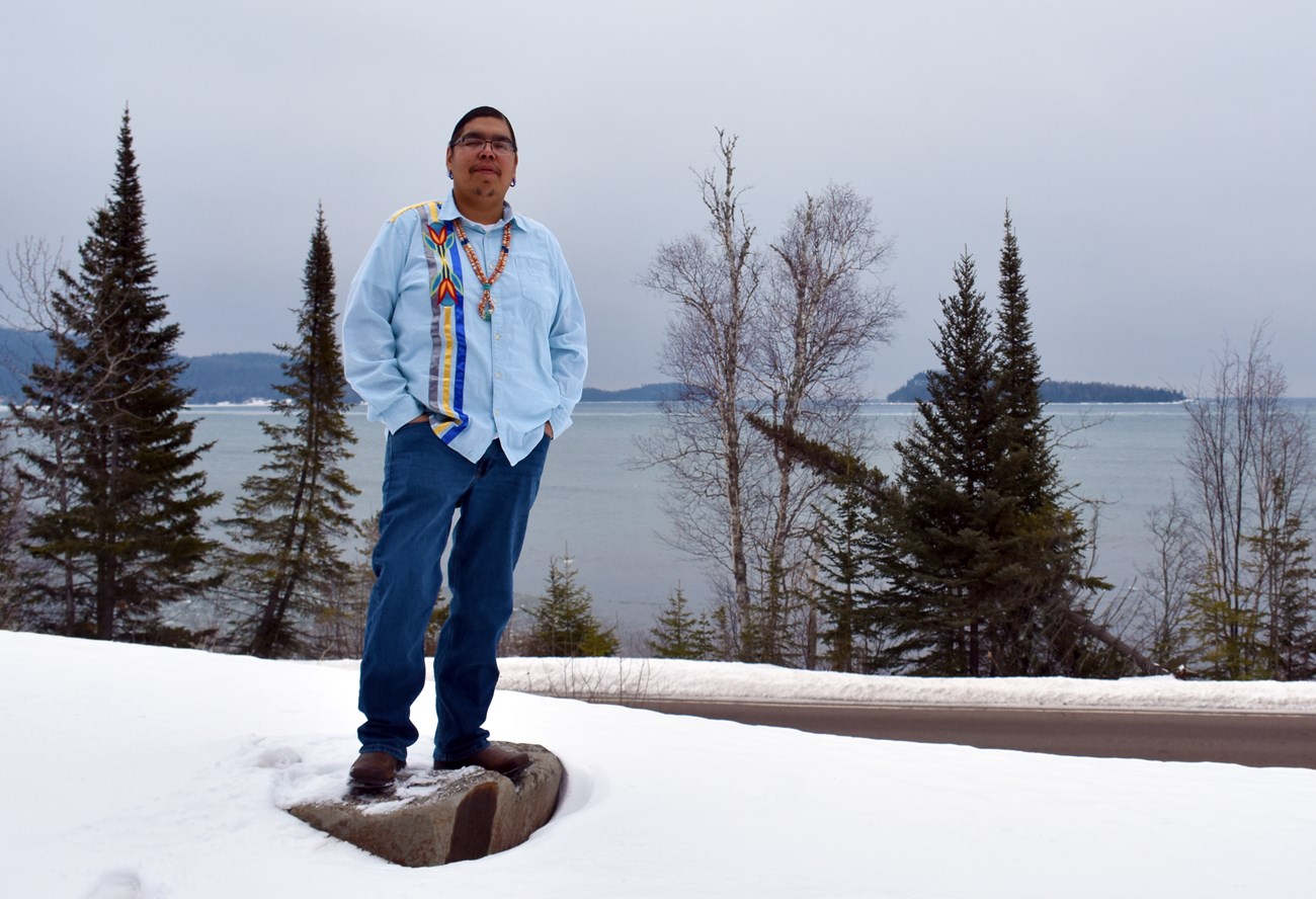 Nate Meshake A person wearing traditional clothing, standing in front of a foggy bay.