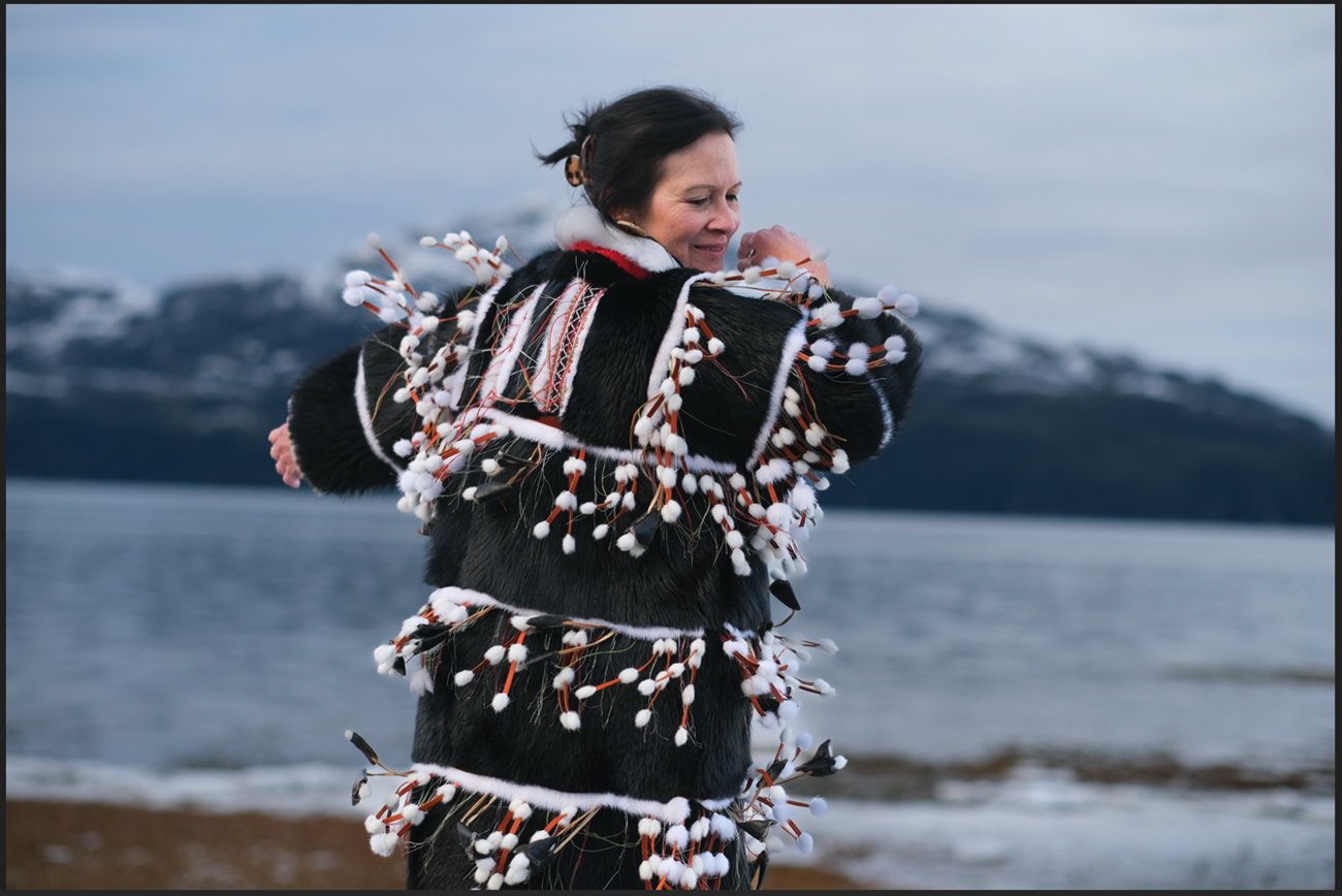 Woman dancing in traditional Sugpiaq regalia.
