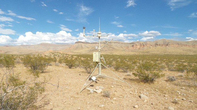 Weather station in Parashant National Monument Weather monitoring station amidst creosote shrubland slopes of hills and mesas in background.