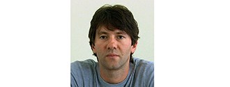 Nickolay Hristov Headshot of a man with brown hair in a blue shirt