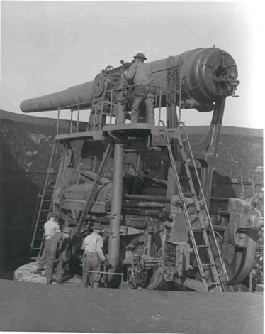a group of soldiers ready a gun for firing