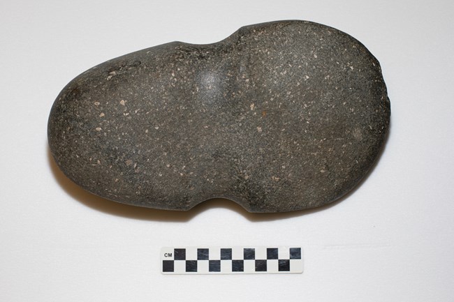 Full groove axe Gray stone axe head with a concave groove around the center.