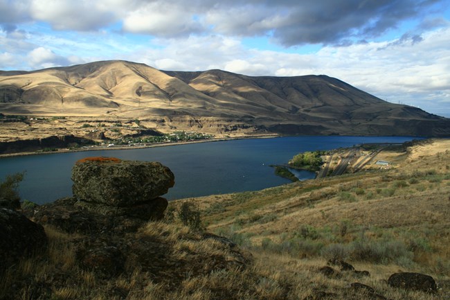 A view looking out on a large river, cutting through high canyon walls.