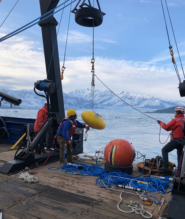 People working on a ship deck to launch equipment.
