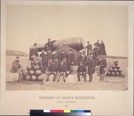 A group off officers around a rodman cannon 1864. A woman stands on the right.