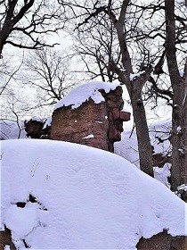 Column of stone shaped like a face in snow