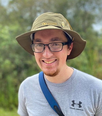 Headshot of Wayne wearing a hat