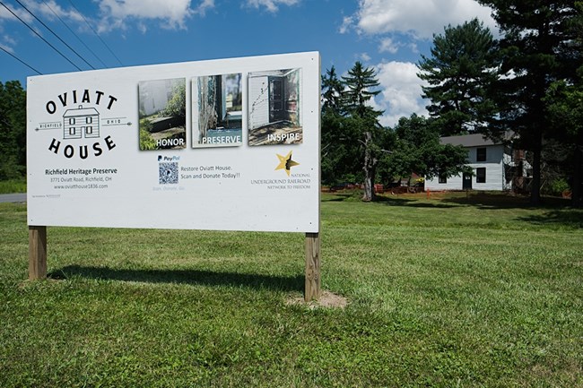 Oviatt House and Sign Photograph of a white large sign stands in front of the Oviatt House. The sign reads: Oviatt House Richfield Ohio Richfield Historical Preserve.