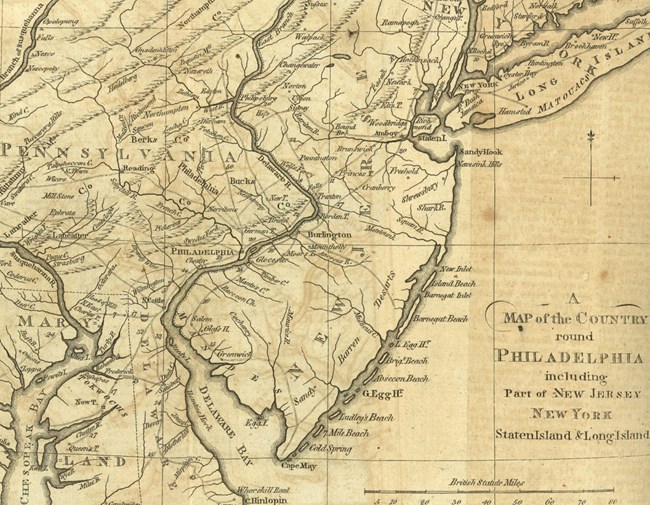 Historic map from 1776 depicts New Jersey’s major towns and rivers, as well as settlements in nearby Pennsylvania, Maryland, and New York, in black ink on a parchment background. NJ’s southeast coast is labeled as “Sandy Barren [Deserts].”