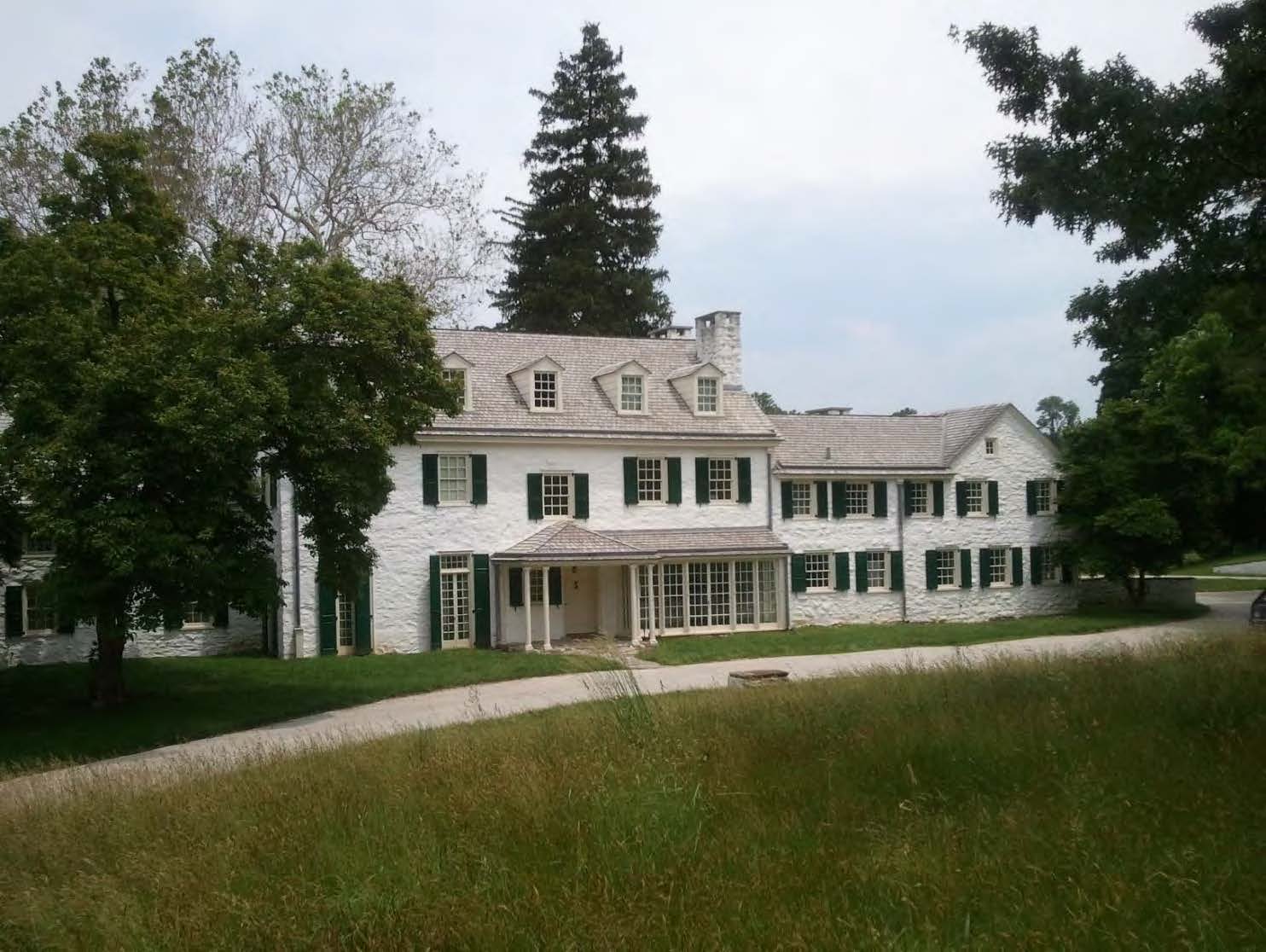 a large white house with a tree in front