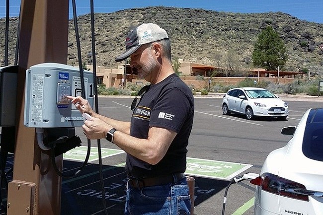 Person charging an electric vehicle