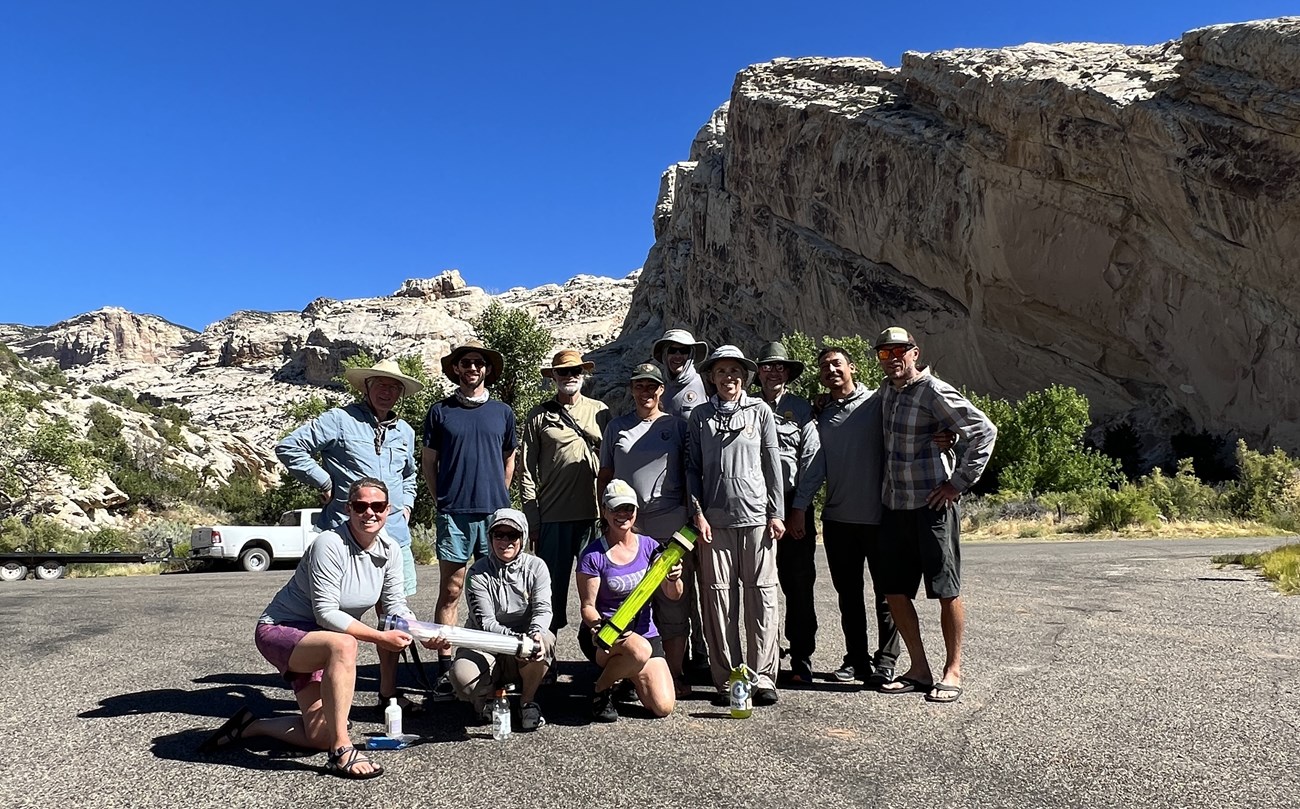 A group of individuals standing on a road taking a group image.