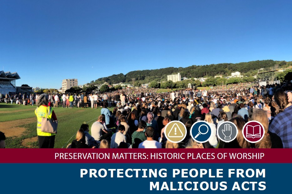 PMB Protecting People Cover Photo A large crowd of people standing on a grassy field facing away from the camera with their heads bent.