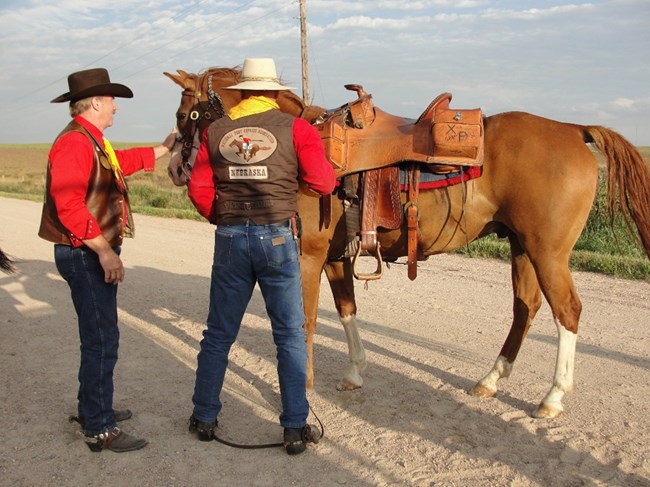 A Pony Express Re-Rider passes the mochila to the next Rider and horse. Photo credit Mary Cone, NPEA. A Pony Express Re-Rider passes the mochila to the next Rider and horse. Photo credit Mary Cone, NPEA.