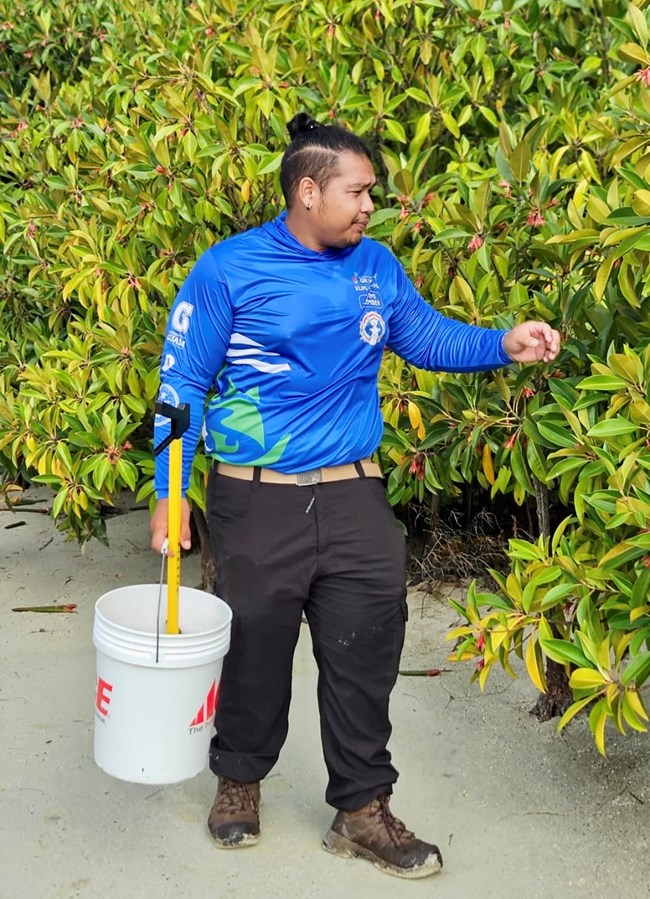 Pacific Islands Conservation Corps intern Isaiah Joel Torre, American Memorial Park Intern collecting mangrove propagules and cleaning up a beach