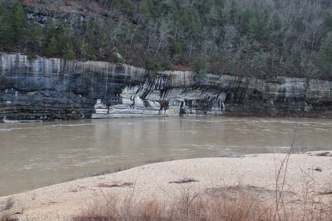 Floodwaters surge at the base of Painted Bluff