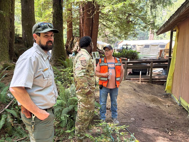 Patrick Pollard 2025 FM of Year Patrick (left) stands in a wooded area with other workers
