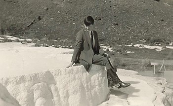 Peg-Lindsley_sleeve-brassard-3-30-1927_Davi-O-Arnold photo Marguerite Lindsley wearing a ranger uniform and holding a stetson hat sitting down on a natural feature with her ankles crossed.