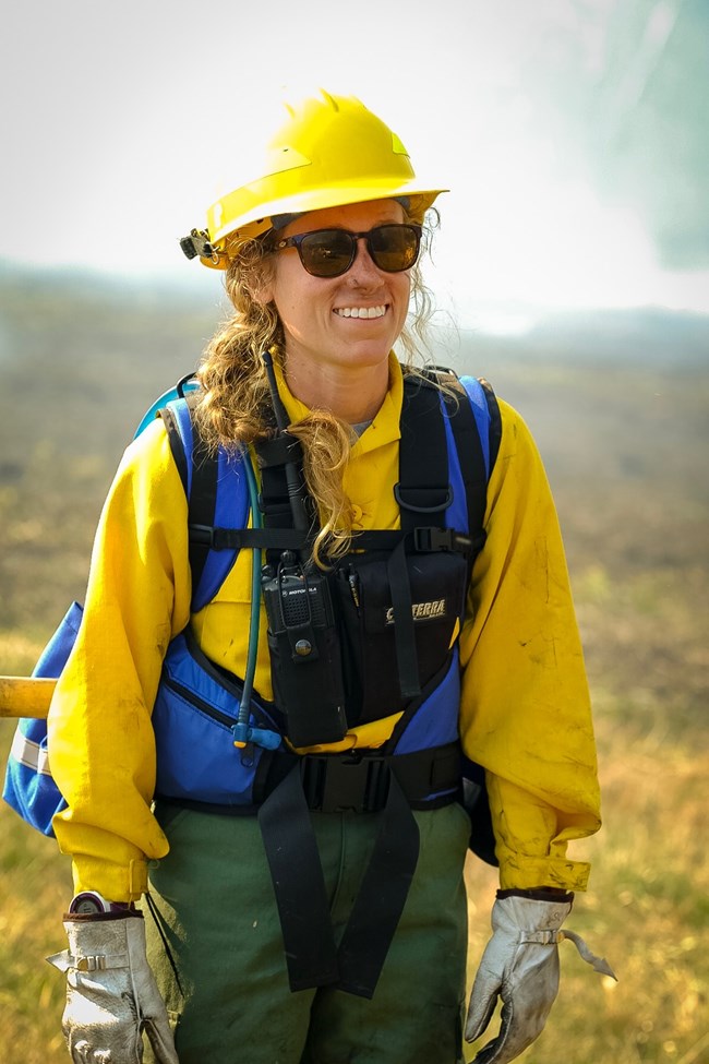 a smiling woman in yellow safety gear