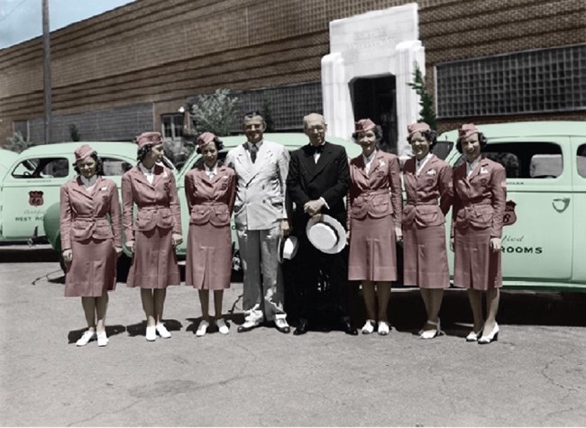 Women dressed in hostess uniforms standing in a line.