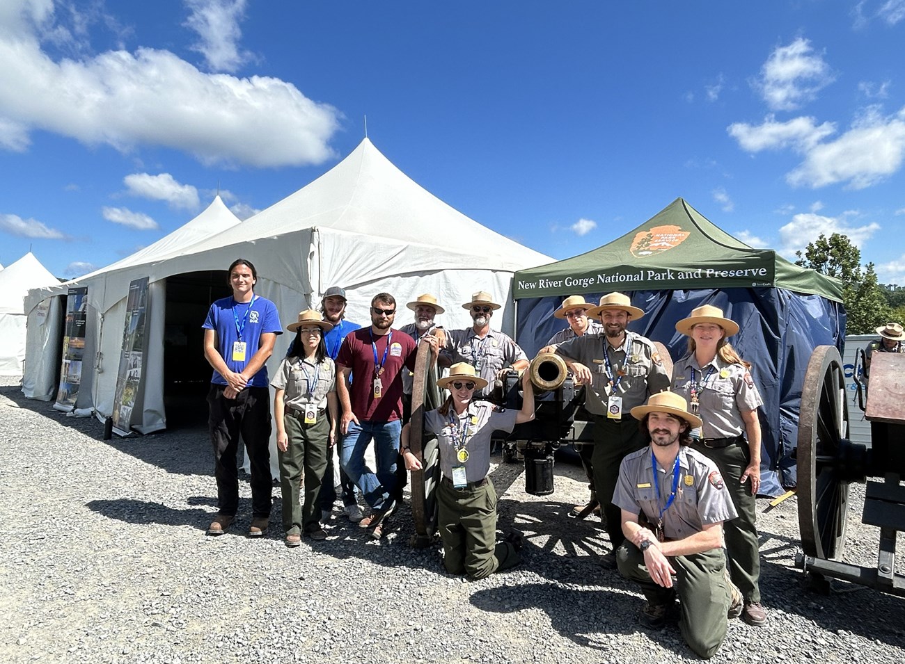 Park rangers and interns pose in front of exhibition tents.