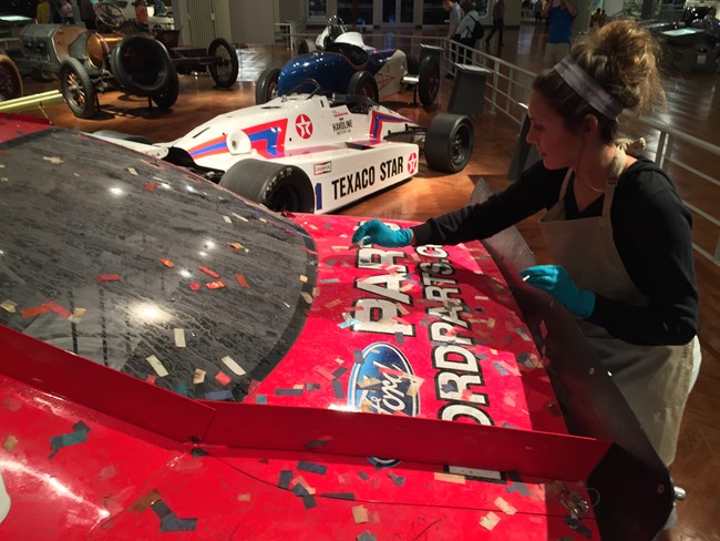 Conservation Specialist Alex Beard dusting the 2011 Ford Fusion Stock Car.