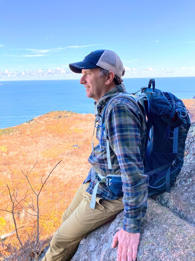 A man looks out over fall foliage