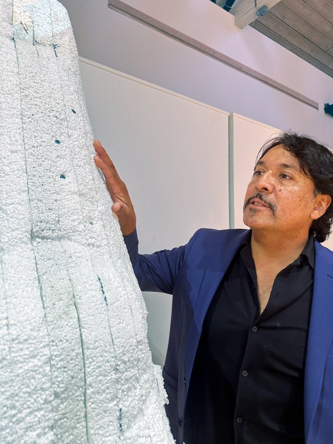 Artist inspects art material.