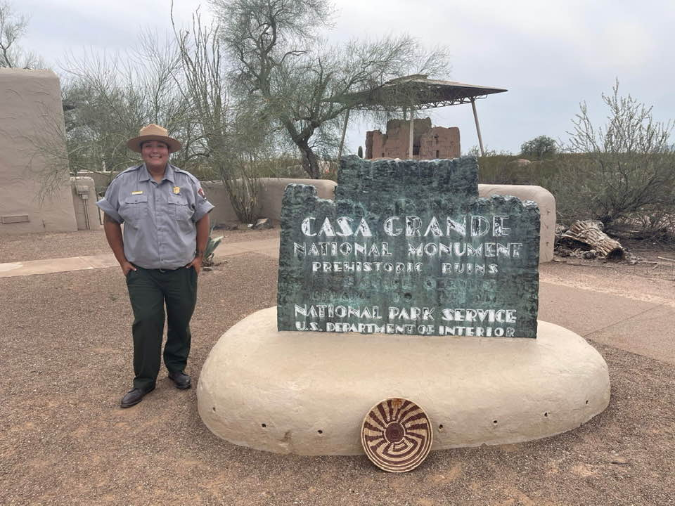 Precious Vicente in uniform in front of the park sign