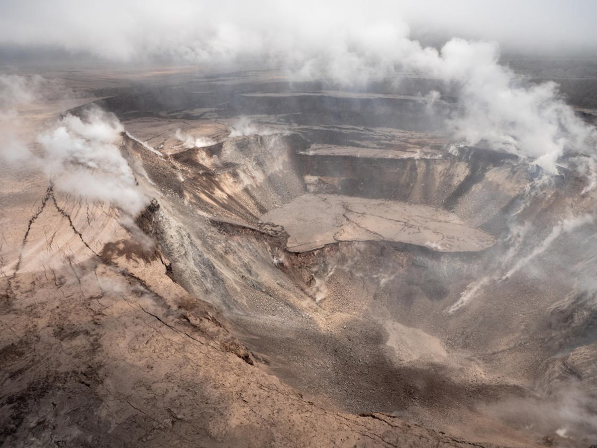 photo of a volcanic crater with plumes of steam