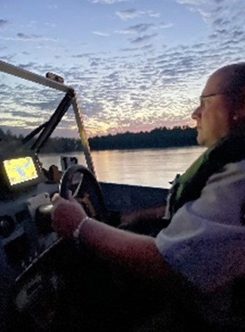 Park Ranger Kevin Grossheim. Photograph of person driving boat.