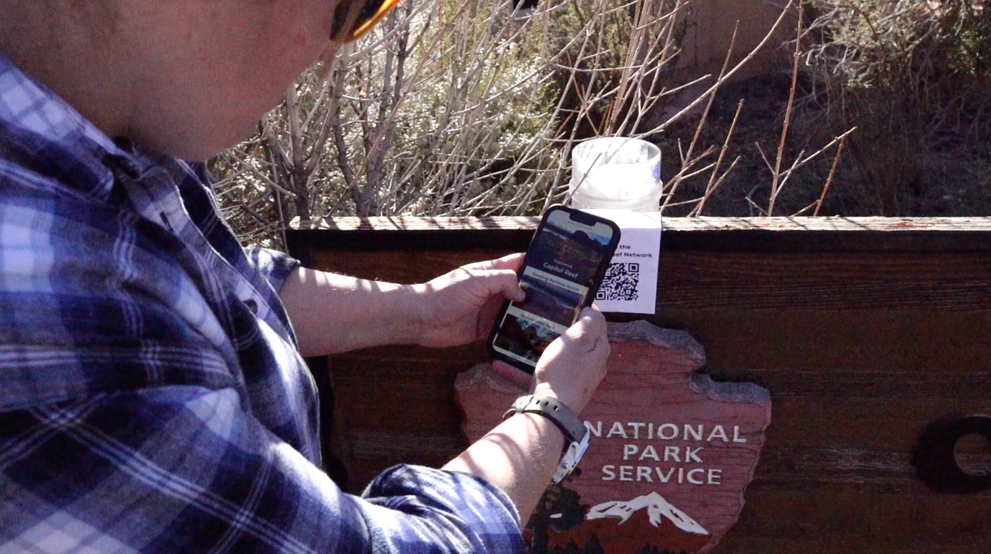 Emily Hedrick using her phone to access interactive features via a QR code Emily Hedrick using her phone to access interactive features via a QR code