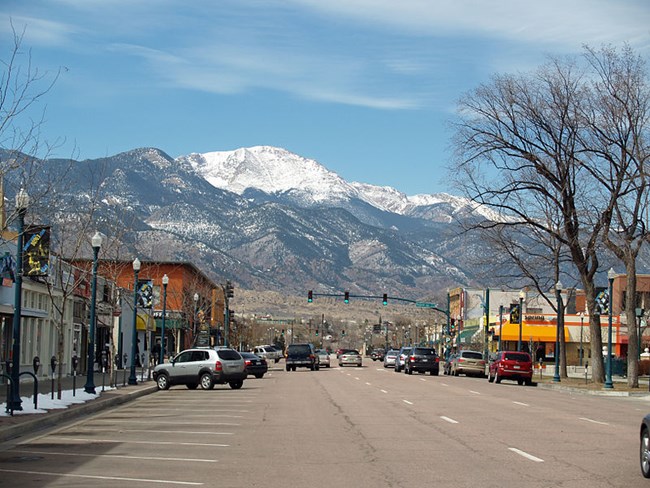 Looking along a commercial street with Pikes Peak and foothills in the distance