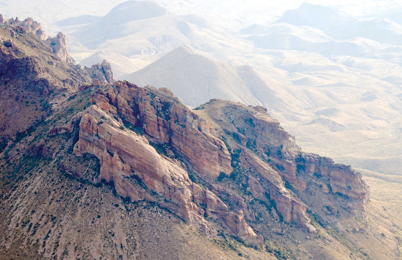 photo of tilted rock cliff bands on a mountain side