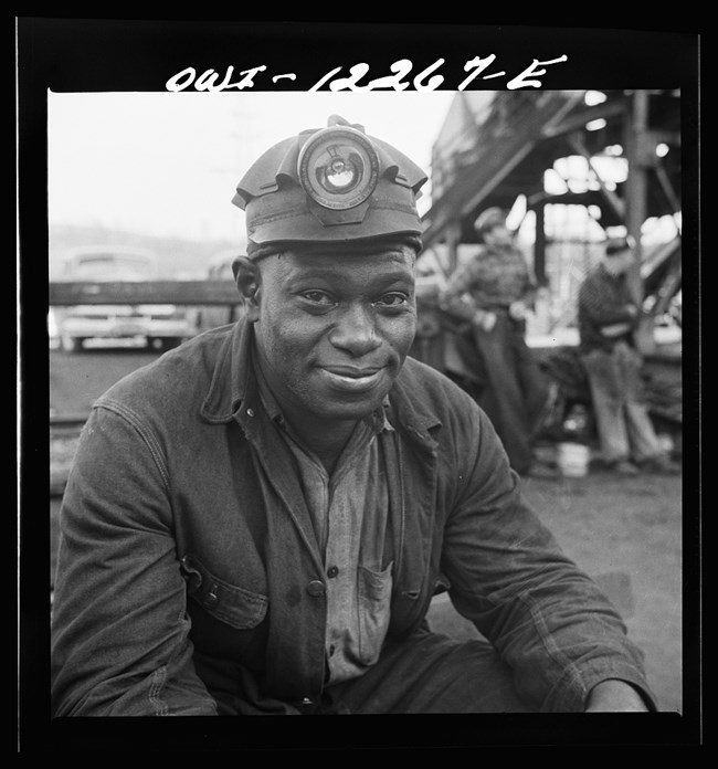 Black and white photo of African American man in headlamp