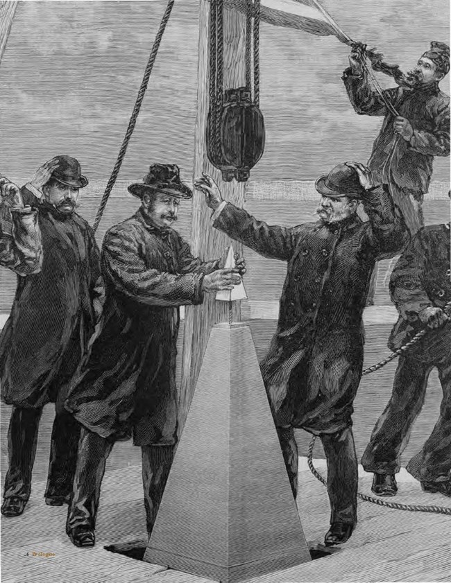 Four men atop the Washington Monument as the tip is placed