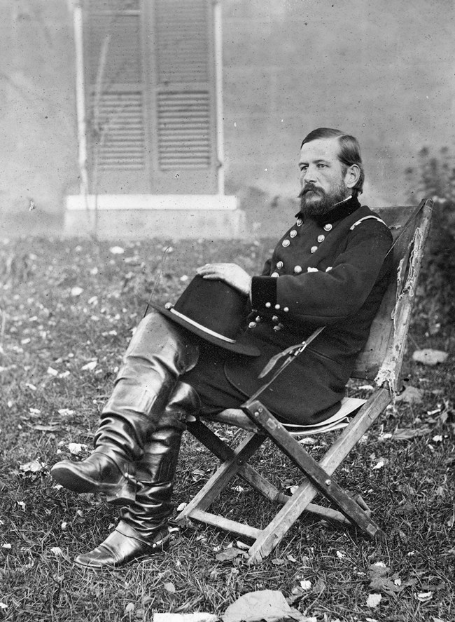 Black and white historical photograph of US Civil War General seated outside.