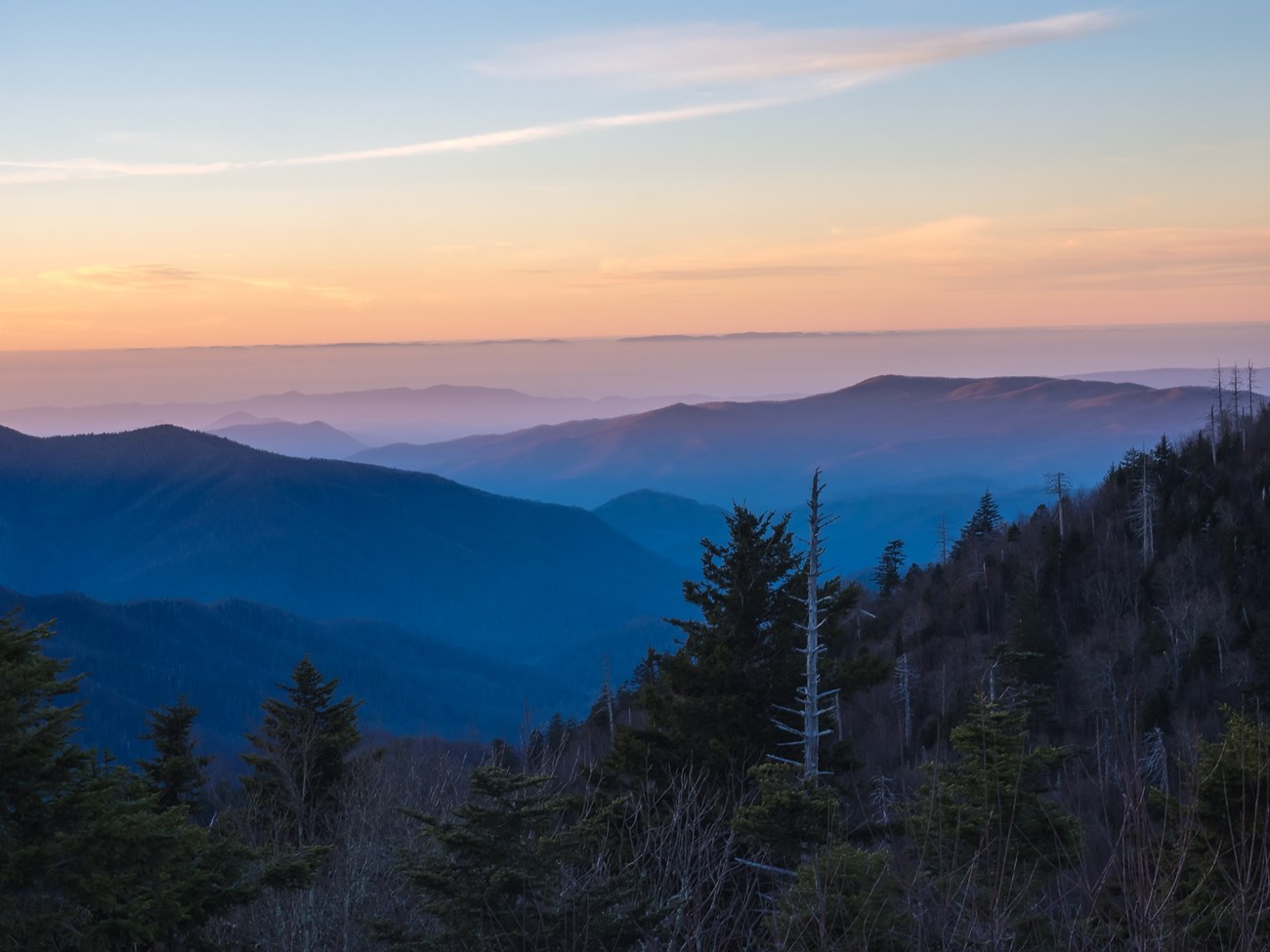 A sunrise scenic mountain view with a mist of smoke.