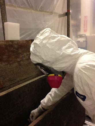 Work in PPE working in an area isolated by plastic sheeting Work in PPE working in an area isolated by plastic sheeting