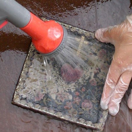 The third photograph shows the underlying textile design being revealed as the rinsing continues.