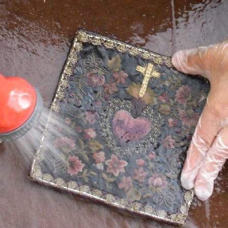 The final photograph shows the intricate detail and various colors of the cleaned textile once the mud and dirt are removed.