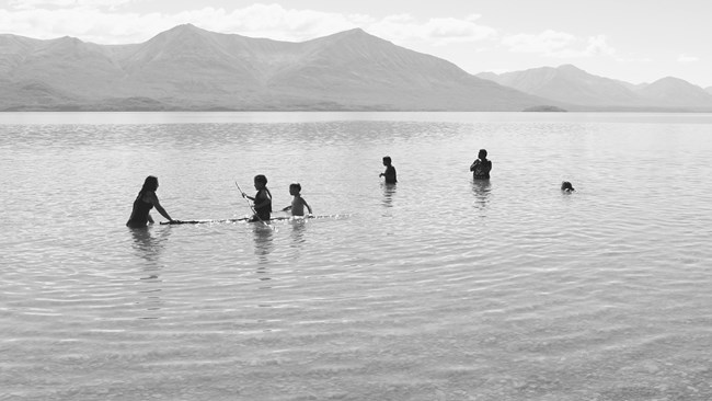 Image of children swimming and playing in a lake.