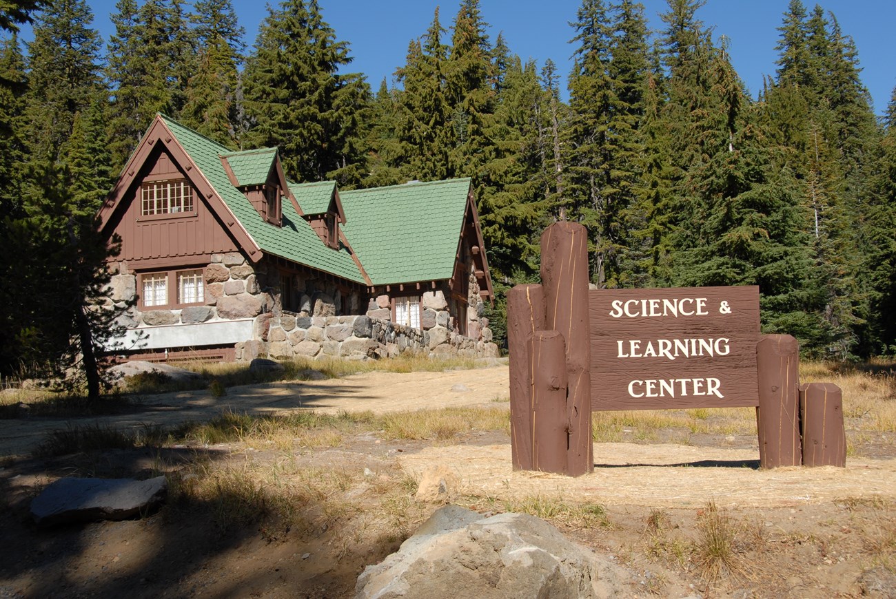 a mountain cabin with a sign that says science and learning center