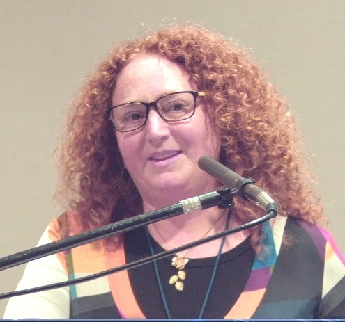 Photo of the presenter, Rachel Feit, at a lectern.