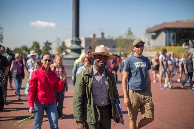 A park ranger walks with a group of visitors on Liberty Island.