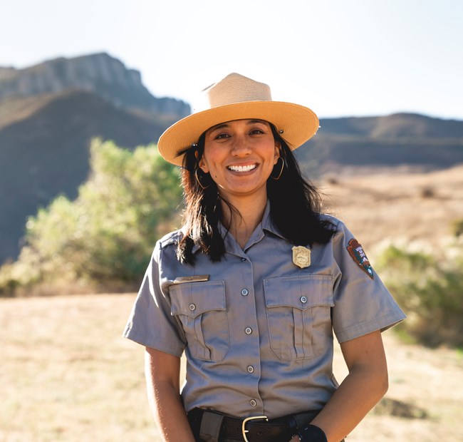Ranger smiling in front of mountains